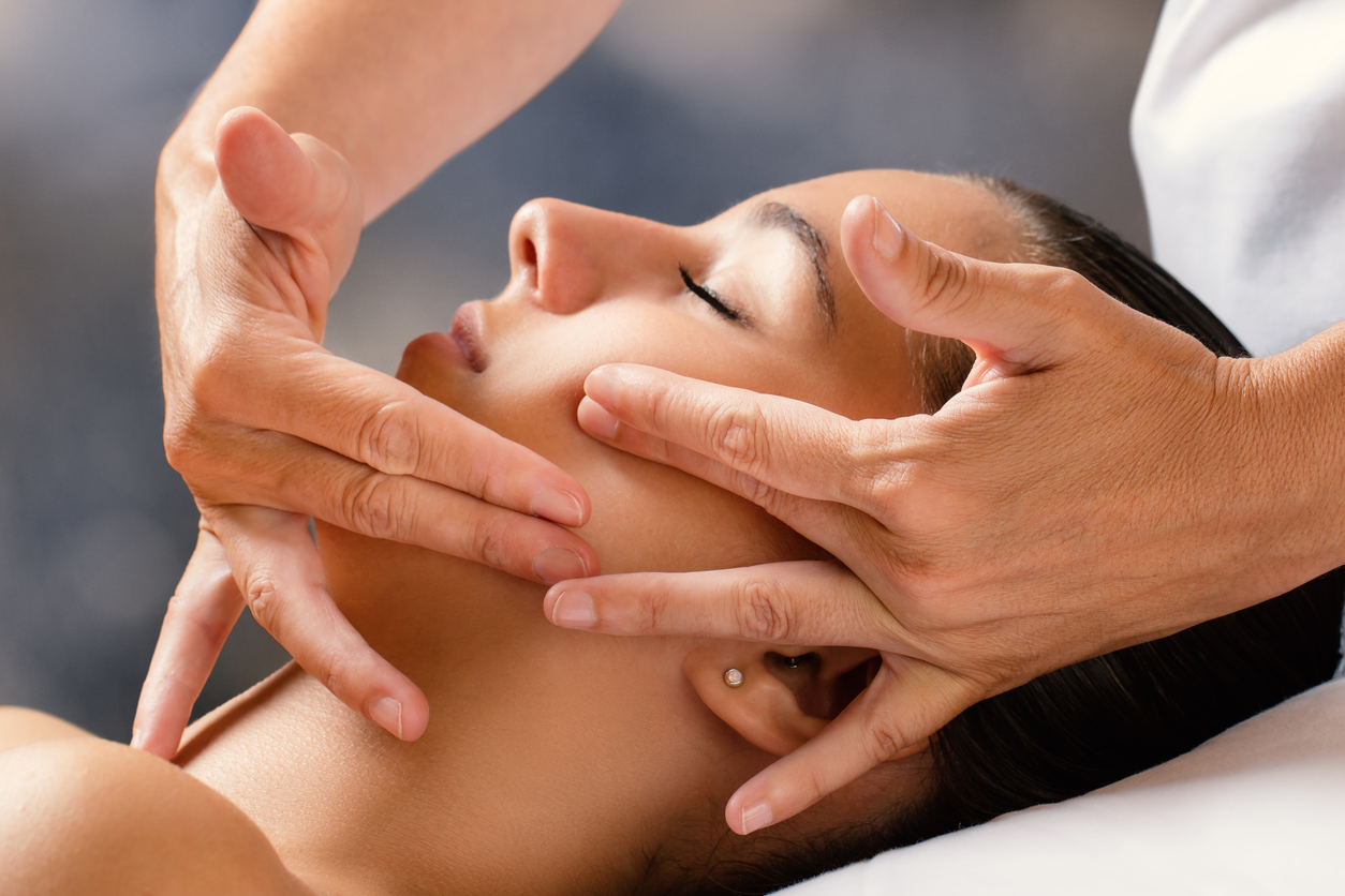 Thérapeute pratiquant un massage facial Kobido